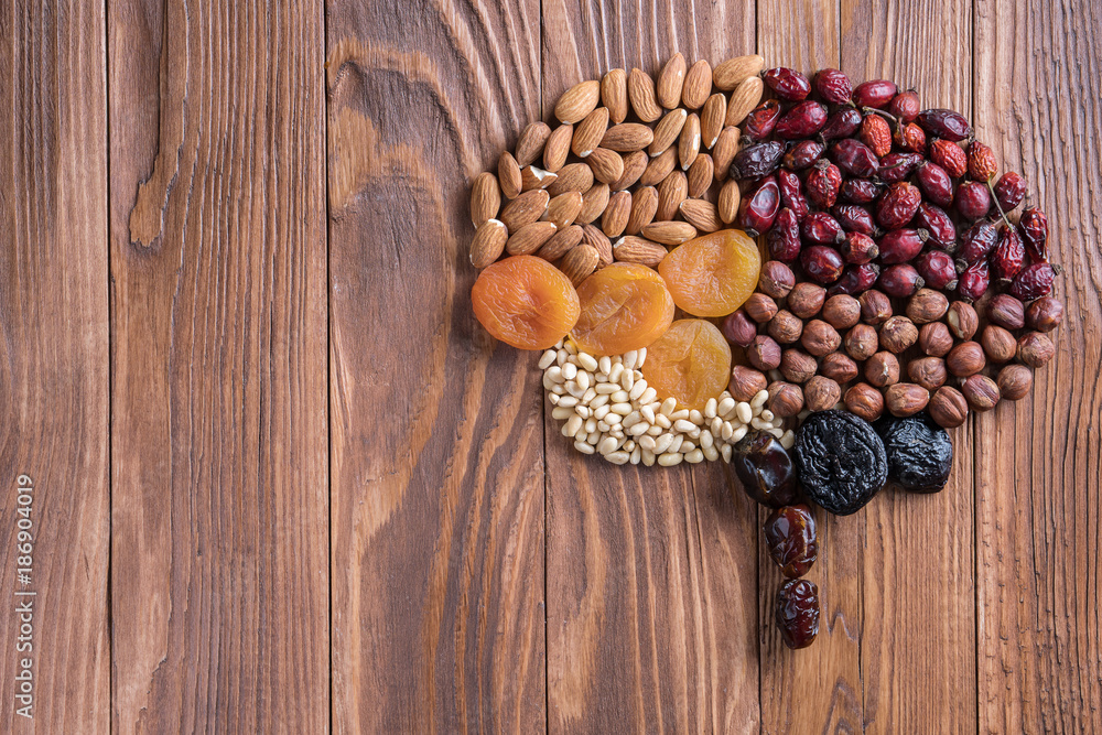 Human brain is made of dried apricots and nuts on a wooden table. Concept of healthy food. Human brain is made of dried apricots and nuts on a wooden table. Concept of healthy food.
