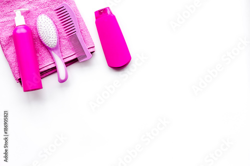 Basic hair care in bathroom. Comb, shampoo, spray, towel on white background top view copyspace