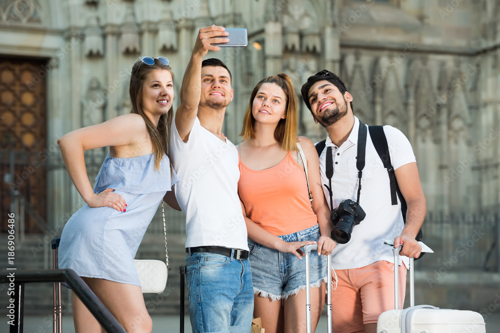 Obraz premium tourists taking selfie on camera in smartphone