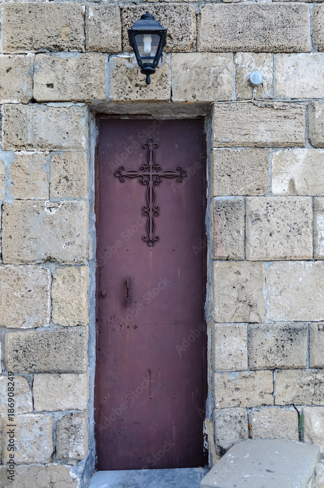 Narrow metal door at a Greek Orthodox church. Narrow metal door at a Greek Orthodox church.