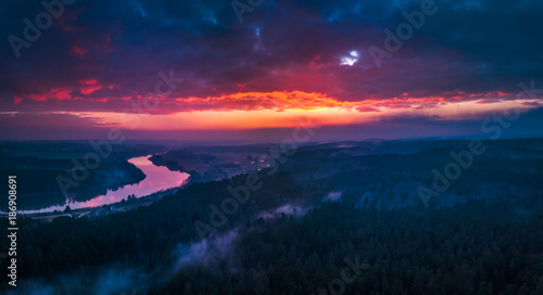 Panoramic aerial view of flying over the forests in the evening