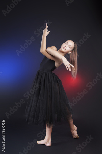 Cute gymnast posing looking at camera. Teenage girl wearing black transparent dress