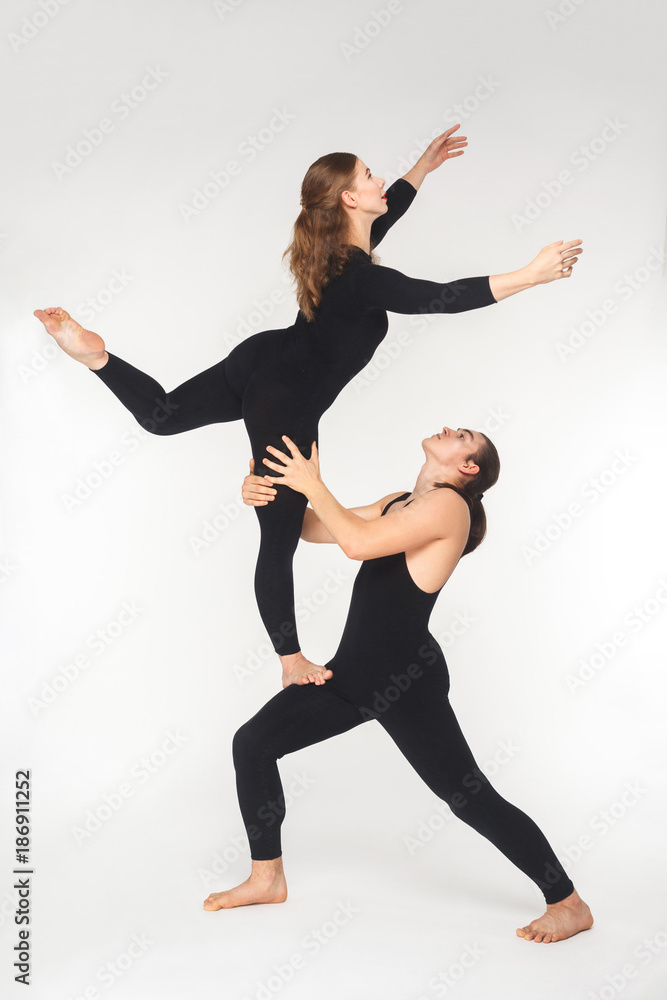 Obraz premium Young adult couple doing acroyoga pose for practicing in balance.