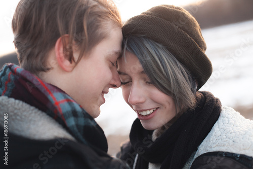 A cheerful young man and woman outdoors at sunset. Winter © Dima Aslanian