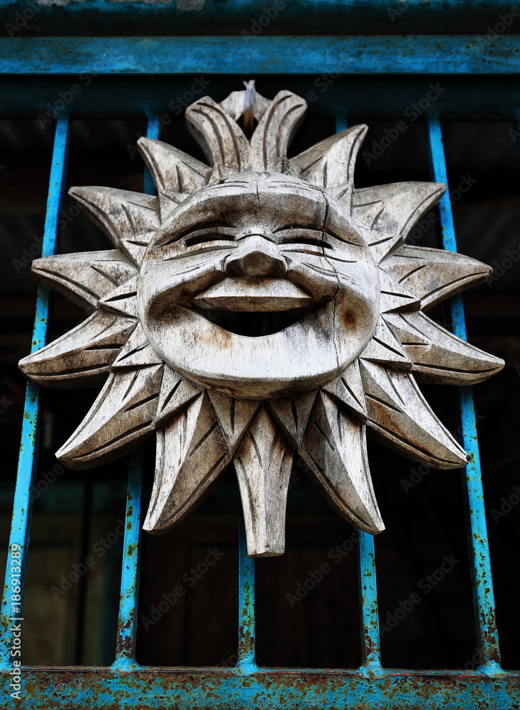 Naklejka premium Smiling sun wood carving-house door in Bocos barangay. Banaue-Ifugao-Philippines. 0075