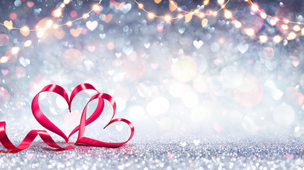 Valentines Card - Red Ribbon Shaped Hearts On Silver Shiny Background With Lights
