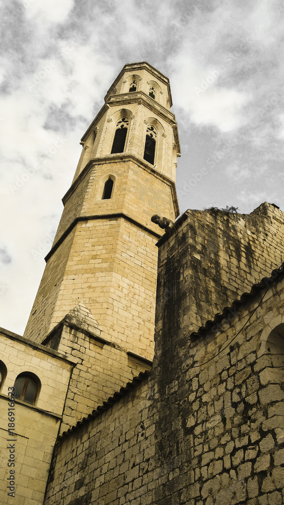 Church of St. Peter in Figueres - Catalonia Spain. Gothic tower with dramatic clouds in the background