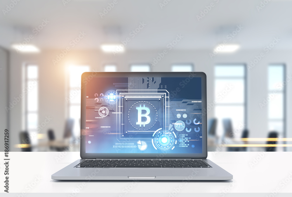 Laptop with a bitcoin symbol in office Laptop with a bitcoin symbol in office