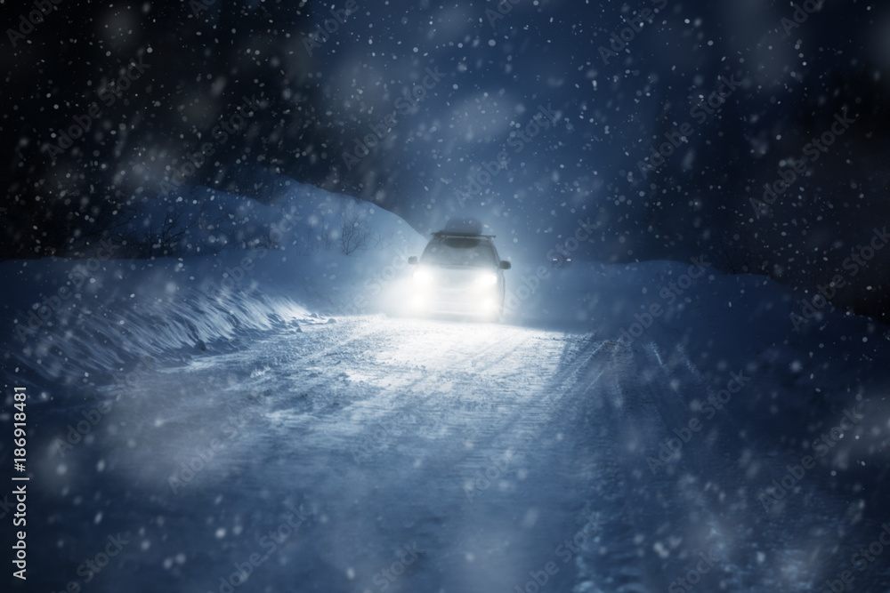 Car lights in winter forest