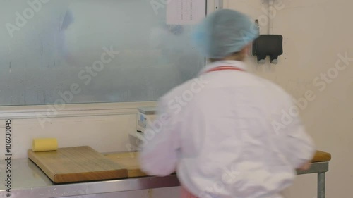 Female factory employee making butter with wooden tools photo