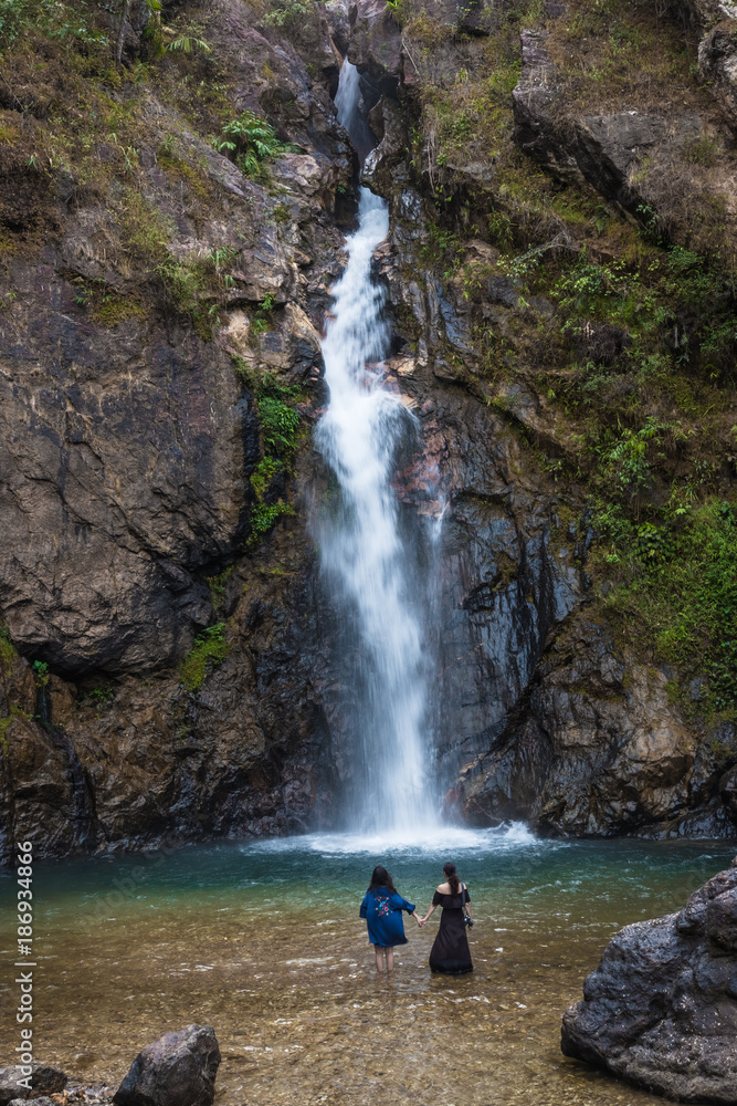 Two women standing in a waterfall. Two women standing in a waterfall.