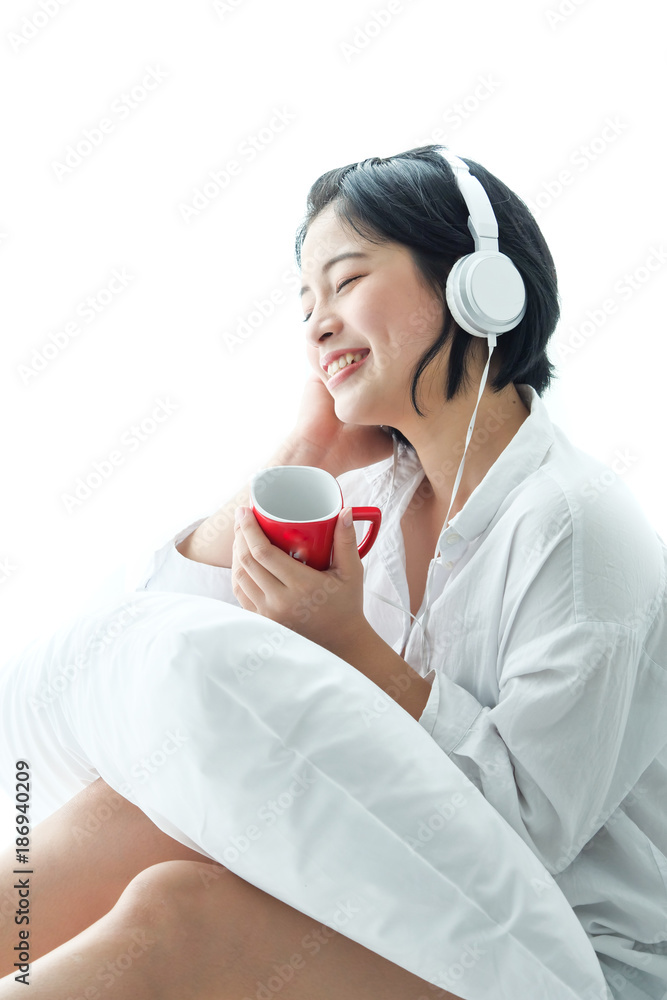 Asian woman drinking coffee in living room and listen music Asian woman drinking coffee in living room and listen music