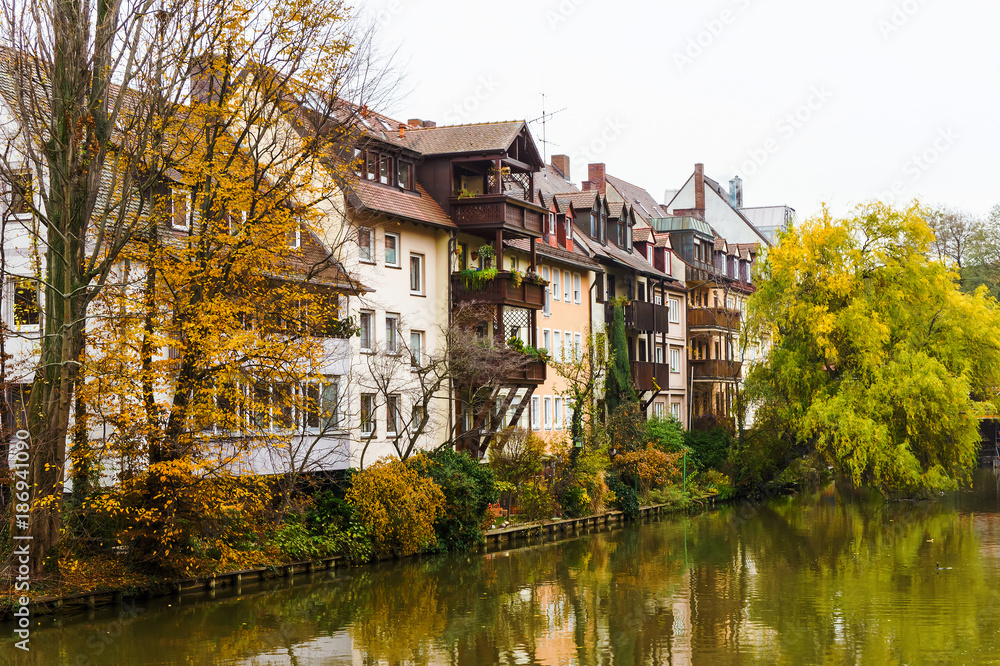 Cityscape from riverside in Nurnberg, river Pegnitz with living houses and trees in Bavarian town, Nuremberg, Germany