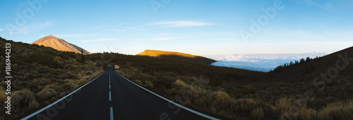 Road with sunrise light on volcanic hills in desert landscape
