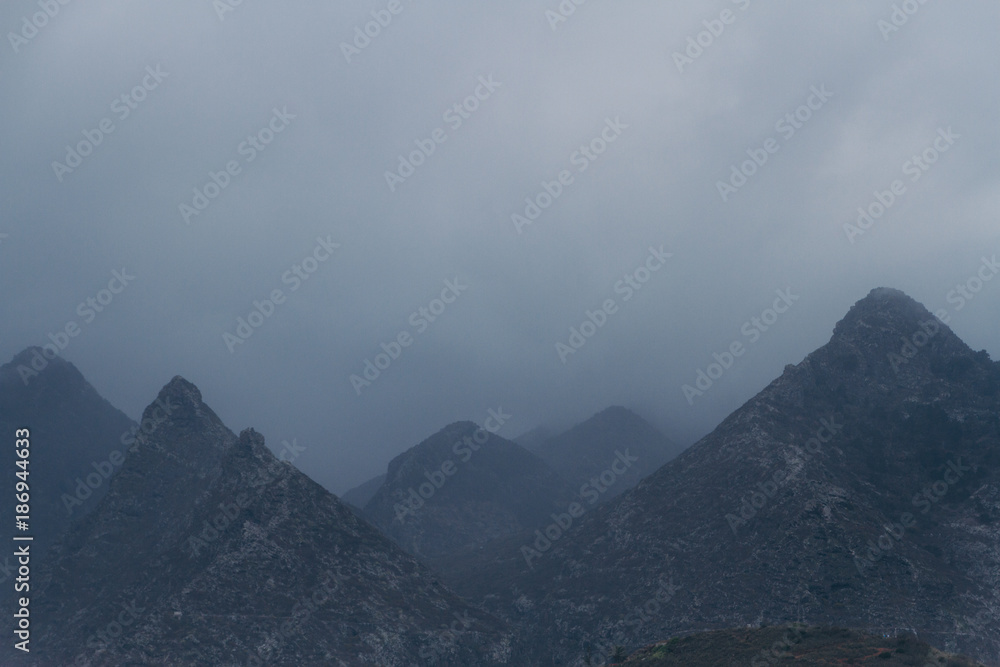 Rocky hills covered in atmospheric fog and clouds Rocky hills covered in atmospheric fog and clouds