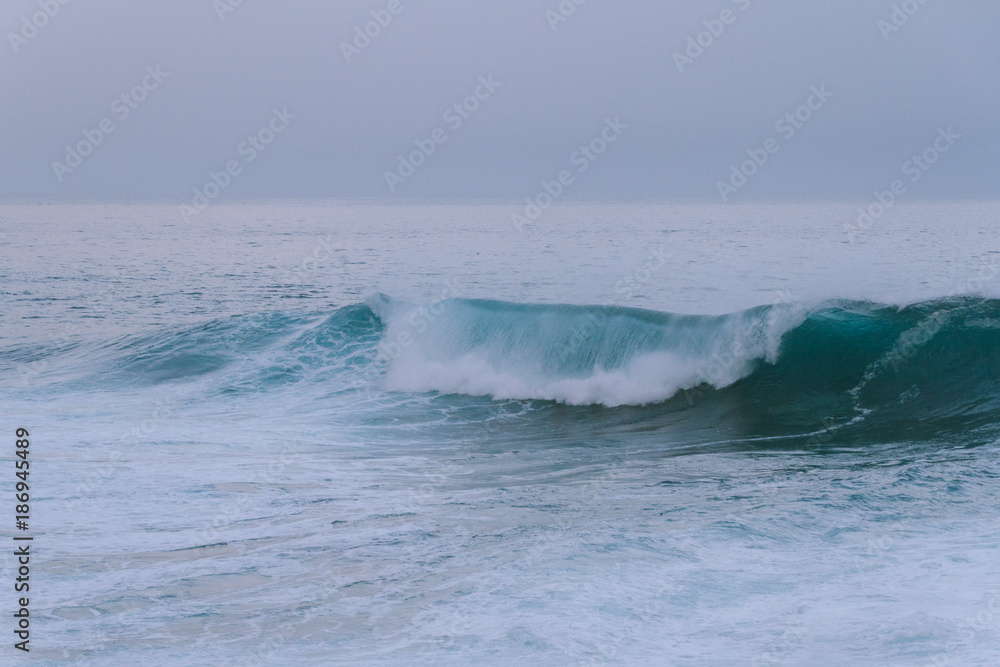 Ocean waves breaking on shore at dawn