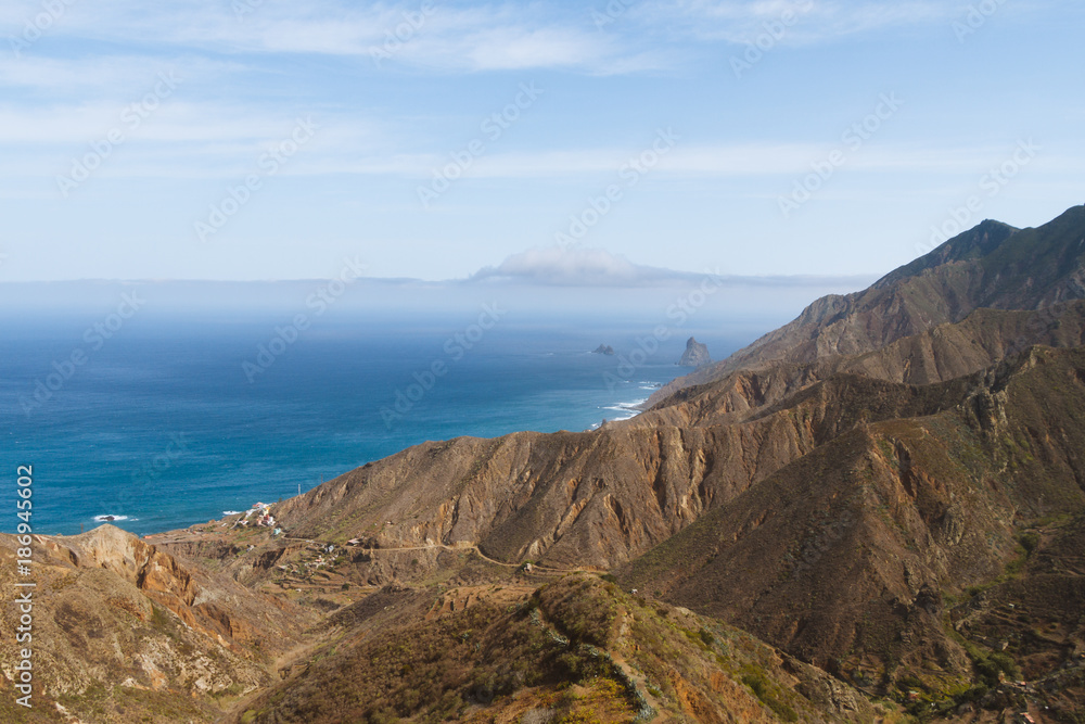 Volcanic landscape with cliffs on coastline during sunny day Volcanic landscape with cliffs on coastline during sunny day