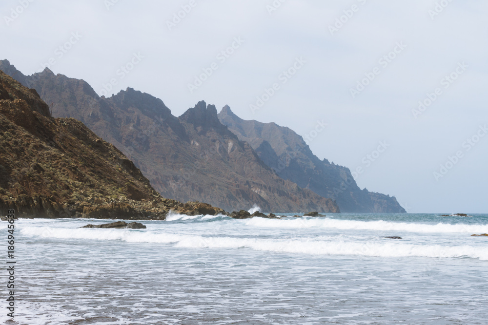 Remote sand beach in volcanic landscape in summer Remote sand beach in volcanic landscape in summer