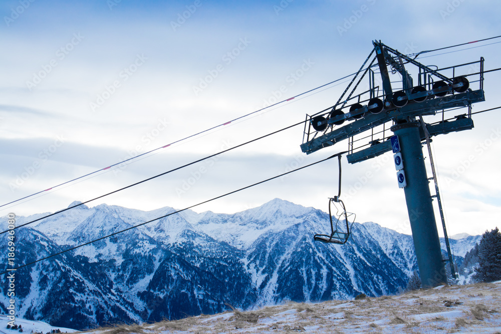 Ski station in the mountains. There is a cable car for skiers. The tops of the snow-capped mountains can be seen. Ski station in the mountains. There is a cable car for skiers. The tops of the snow-capped mountains can be seen.