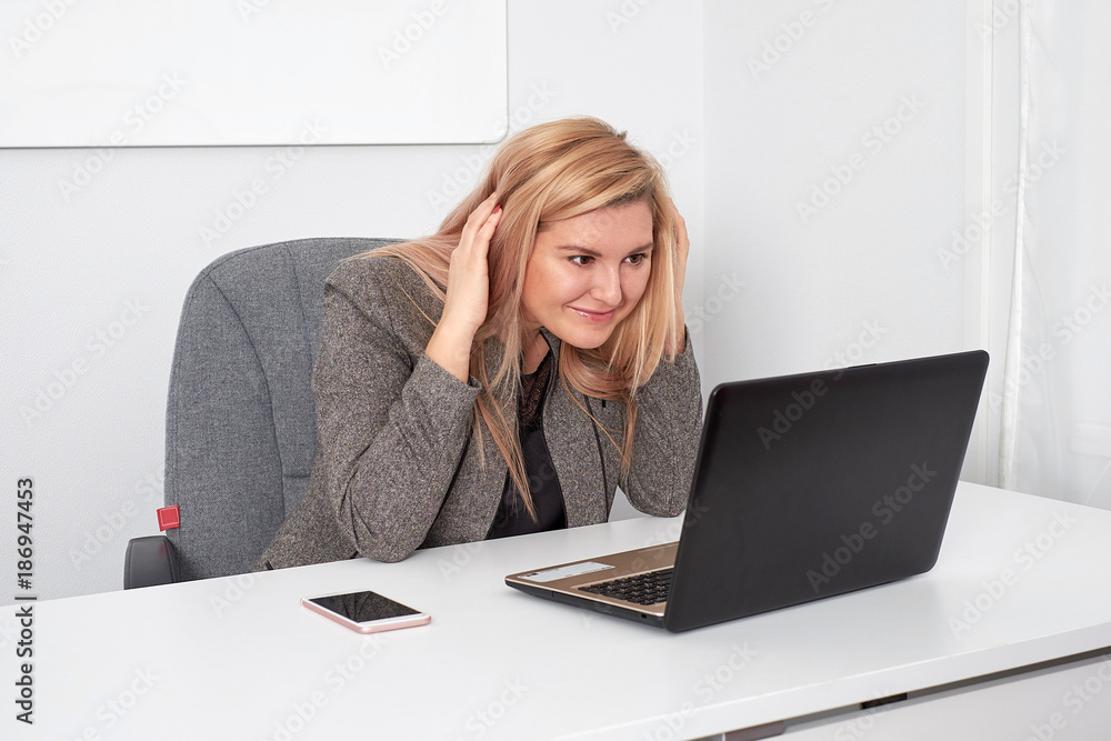 Beautiful business woman is working behind laptop at office Beautiful business woman is working behind laptop at office