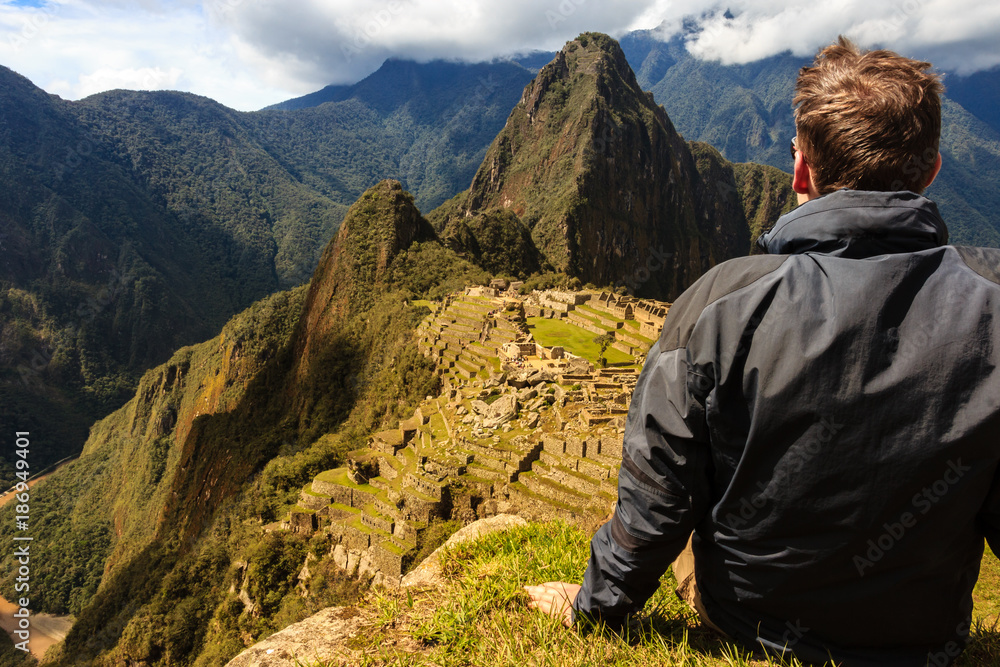 Hiker enjoying the view of Machu Picchu after a strenous ascent / Rastender Wanderer mit Blick auf Machu Picchu