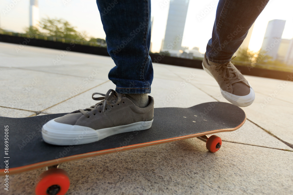 skateboarder legs riding with skateboard at city skateboarder legs riding with skateboard at city