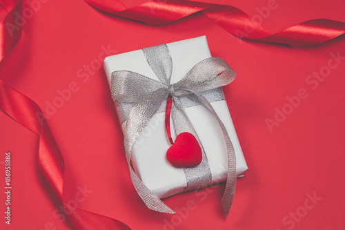 Gift box with hearts on red background. Top view, flat lay. St. Valentine's day greetind concept photo