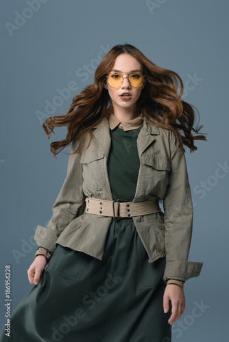 beautiful stylish girl posing in autumn outfit for fashion shoot, isolated on grey