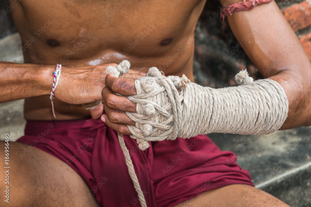 Ancient traditional Muay Thai or Thai boxing fighter putting bandage old  style on the hands preparing to fight Stock Photo | Adobe Stock