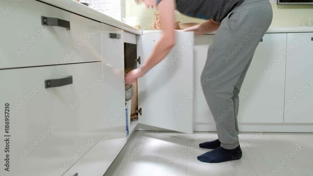 A man puts dirty dishes in the dishwasher A man puts dirty dishes in the dishwasher
