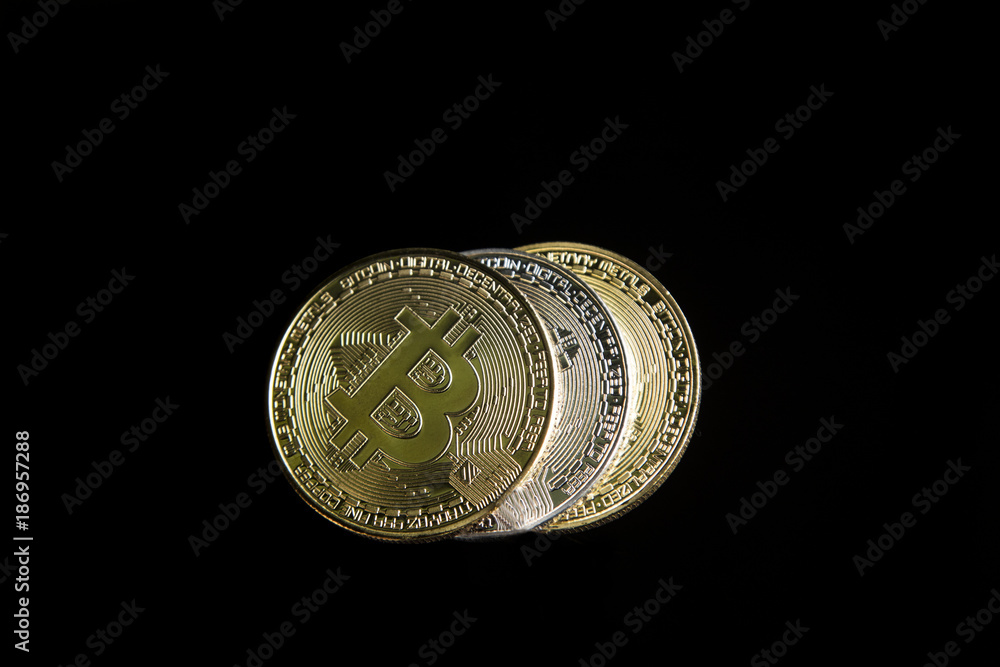 Two gold and one silver bitcoin on black background Two gold and one silver bitcoin on black background
