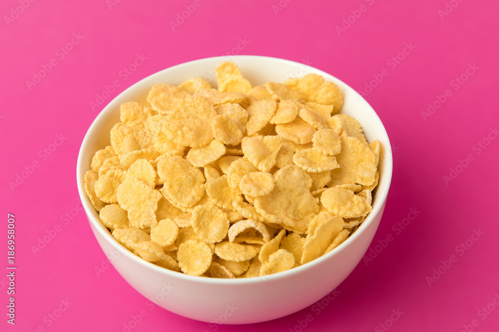 close-up view of white bowl with sweet healthy corn flakes isolated on pink close-up view of white bowl with sweet healthy corn flakes isolated on pink