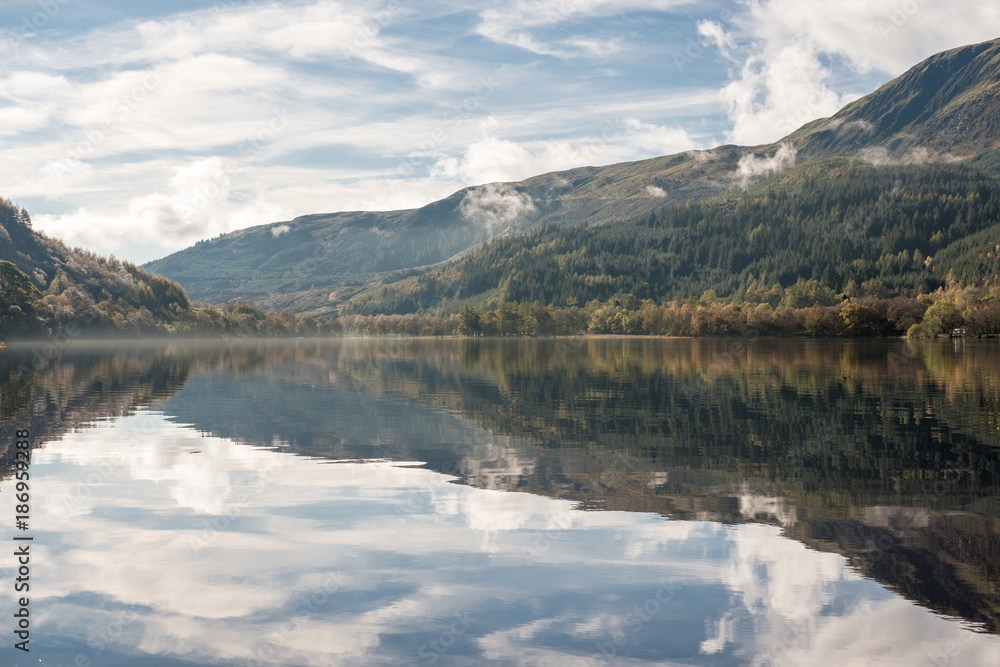 Loch Lubnaig, a part of the Loch Lomond & Trossachs National Park in Scottish Highlands. Reflection of Tree and Mountain on water, in Autumn.