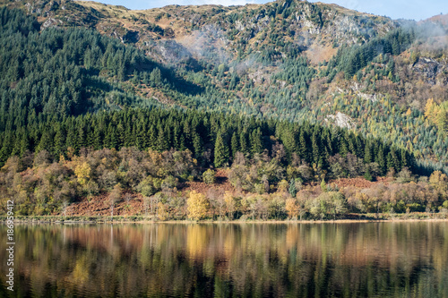 Loch Lubnaig, a part of the Loch Lomond & Trossachs National Park in Scottish Highlands. Reflection of Tree and Mountain on water, in Autumn. photo