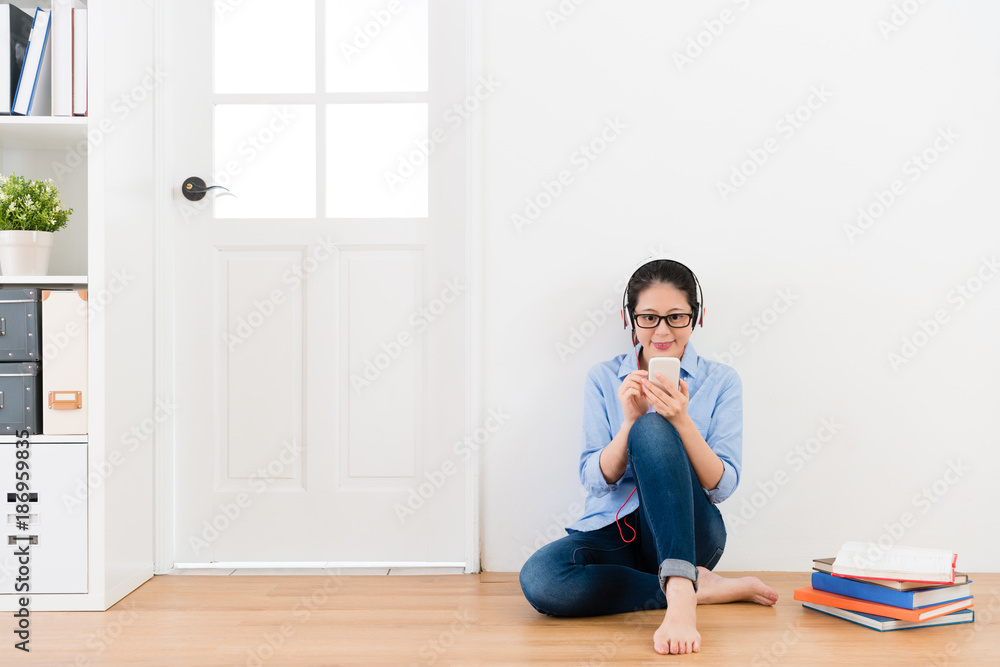 young lady wearing headset sitting on wooden floor young lady wearing headset sitting on wooden floor