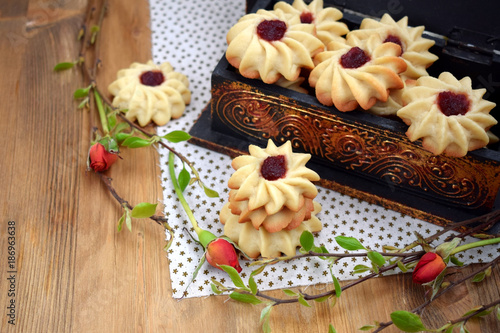 Shortbread cookies with jam on a cloth surrounded by branches