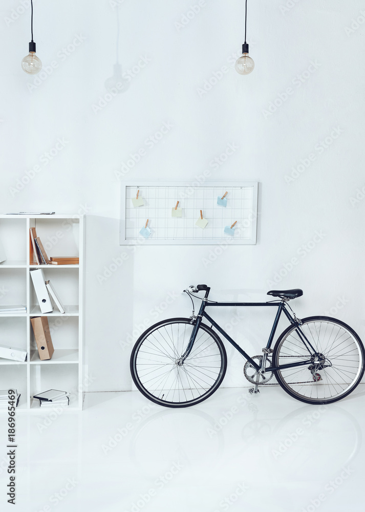 bicycle near wooden shelves in empty office bicycle near wooden shelves in empty office
