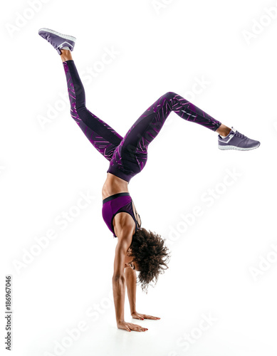 Fototapeta Silhouette of young african girl practicing handstand exercise isolated on white background