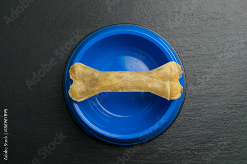 Chewing bone for dogs in a blue dog bowl