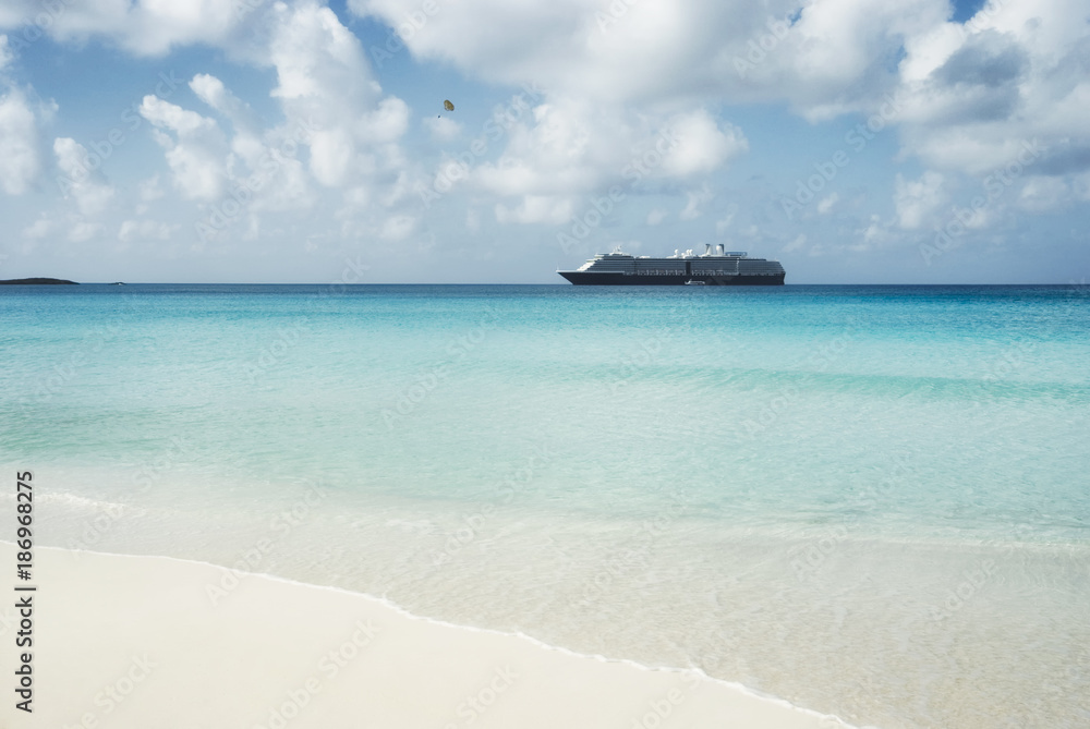 Beautiful sand beach with crystal clear water and cruise ship anchored, Bahamas