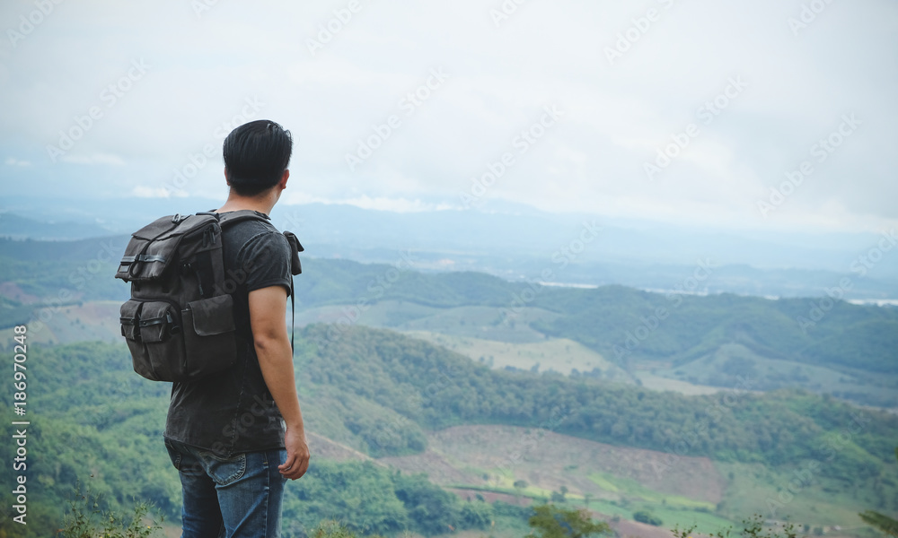 Asian man backpacker/traveler over high view of top mountain landscape in nature