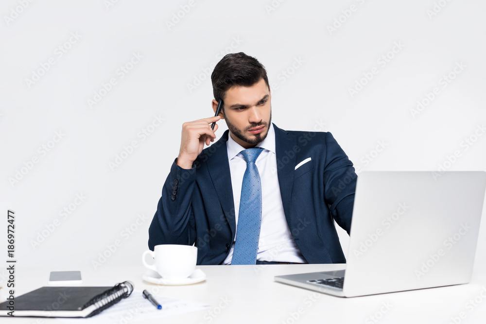 focused young businessman using laptop at workplace on grey focused young businessman using laptop at workplace on grey
