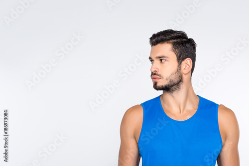 portrait of handsome young sportive man looking away isolated on white