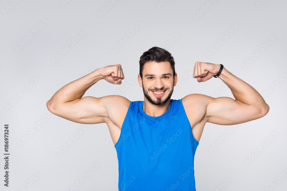 happy young man showing biceps isolated on white happy young man showing biceps isolated on white