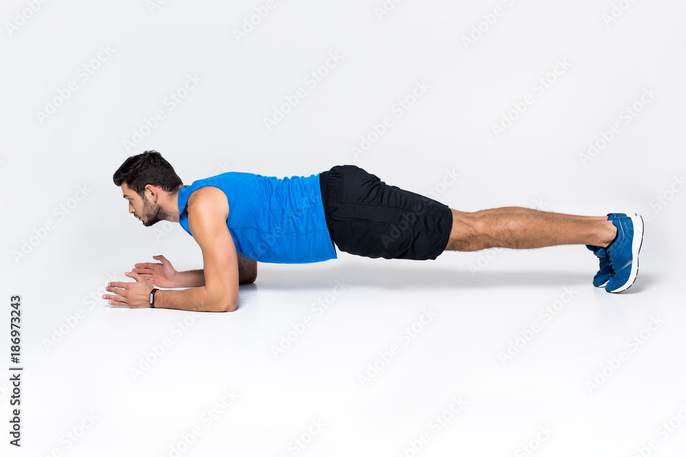 sportive young man doing plank on white sportive young man doing plank on white