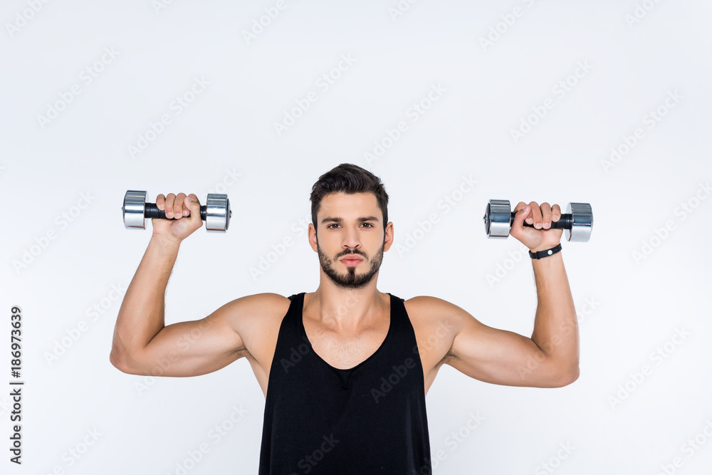 handsome young man working out with dumbbells isolated on white handsome young man working out with dumbbells isolated on white