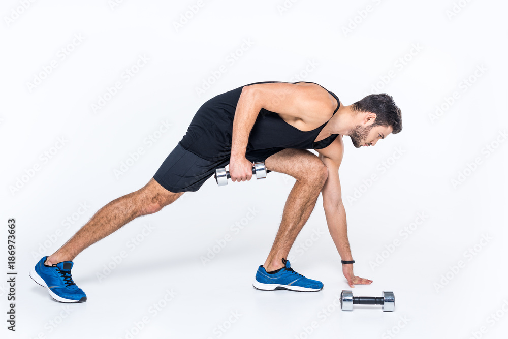 handsome young man working out with dumbbells on white