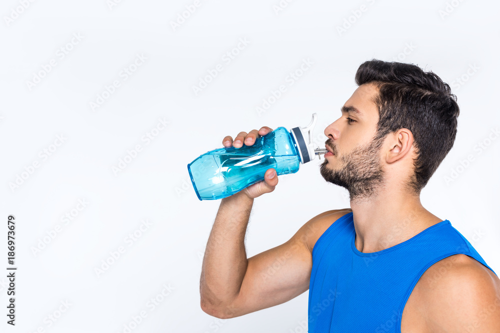 side view of sporty young man drinking water from fitness bottle isolated on white side view of sporty young man drinking water from fitness bottle isolated on white