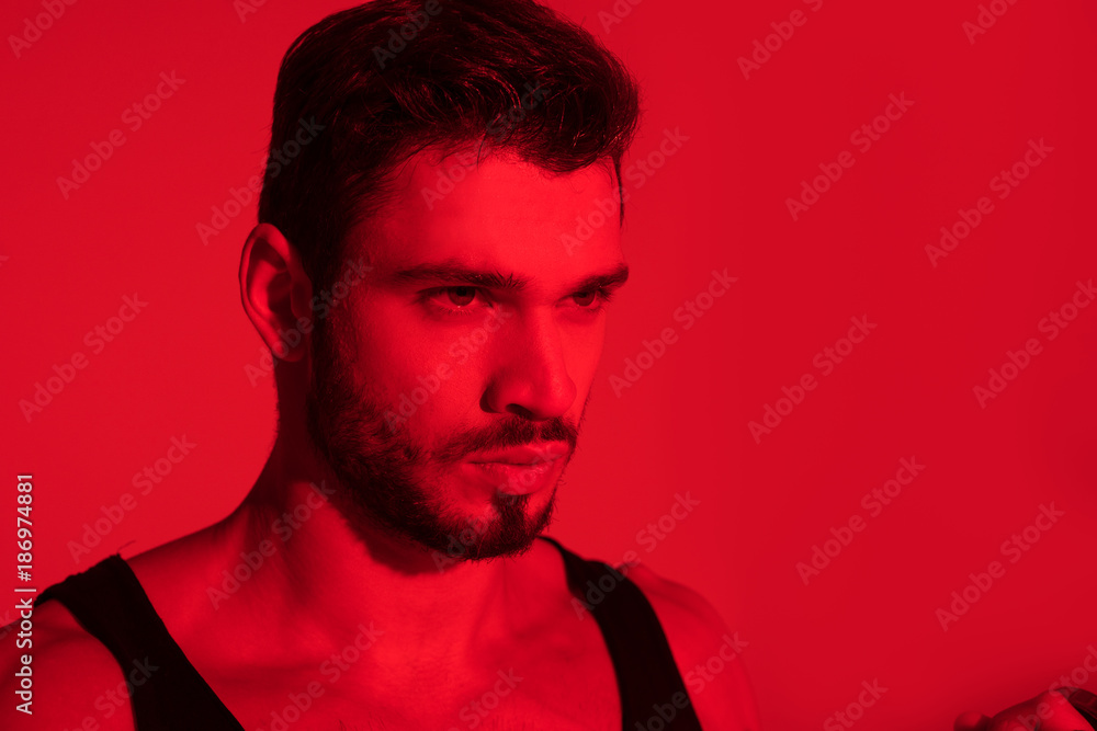 Obraz premium close-up portrait of handsome young man under red light