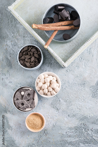 Bowls of licorice roots and different licorice products photo